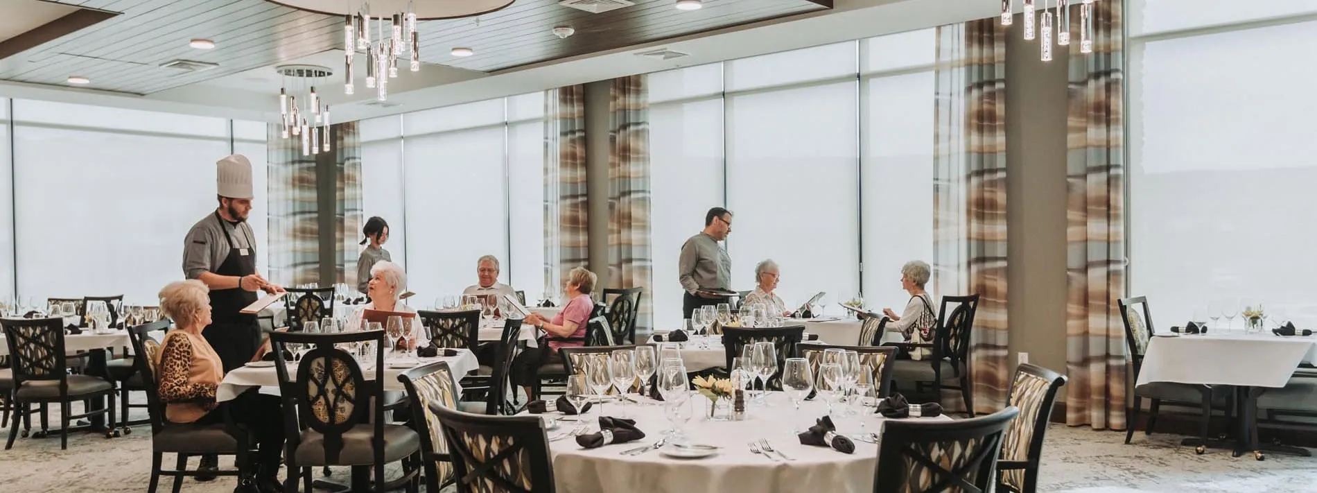 Elegant senior living dining room with residents enjoying chef-prepared meals